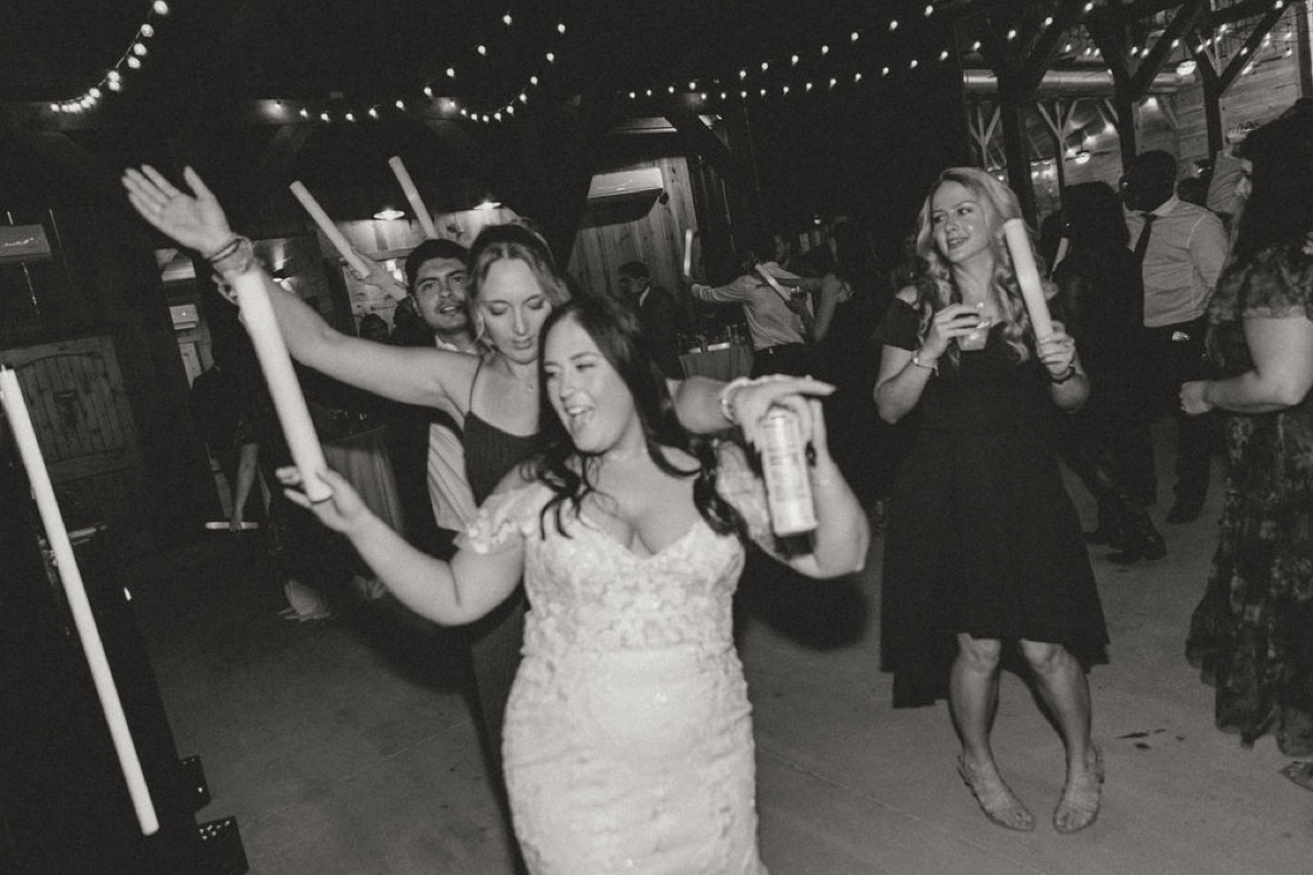 Elizabeth & Ashton’s reception dance at Covey Creek as the bride holds a foam glow stick under string lights