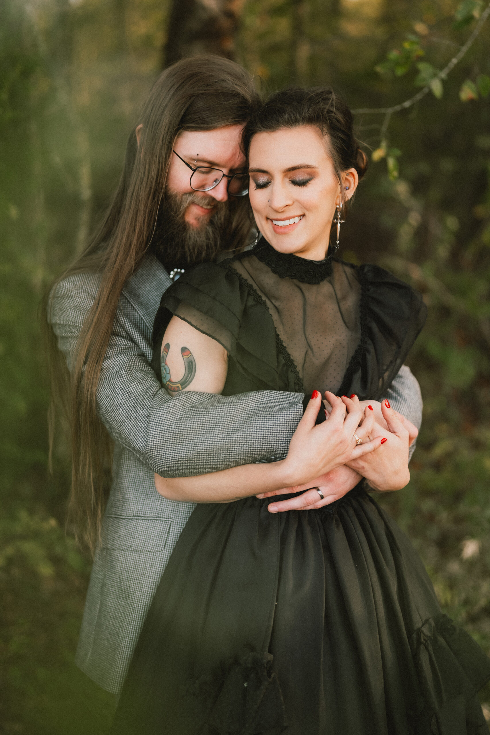 Erin & Baxter embrace with eyes closed, her black lace gown against the woods at Covey Creek