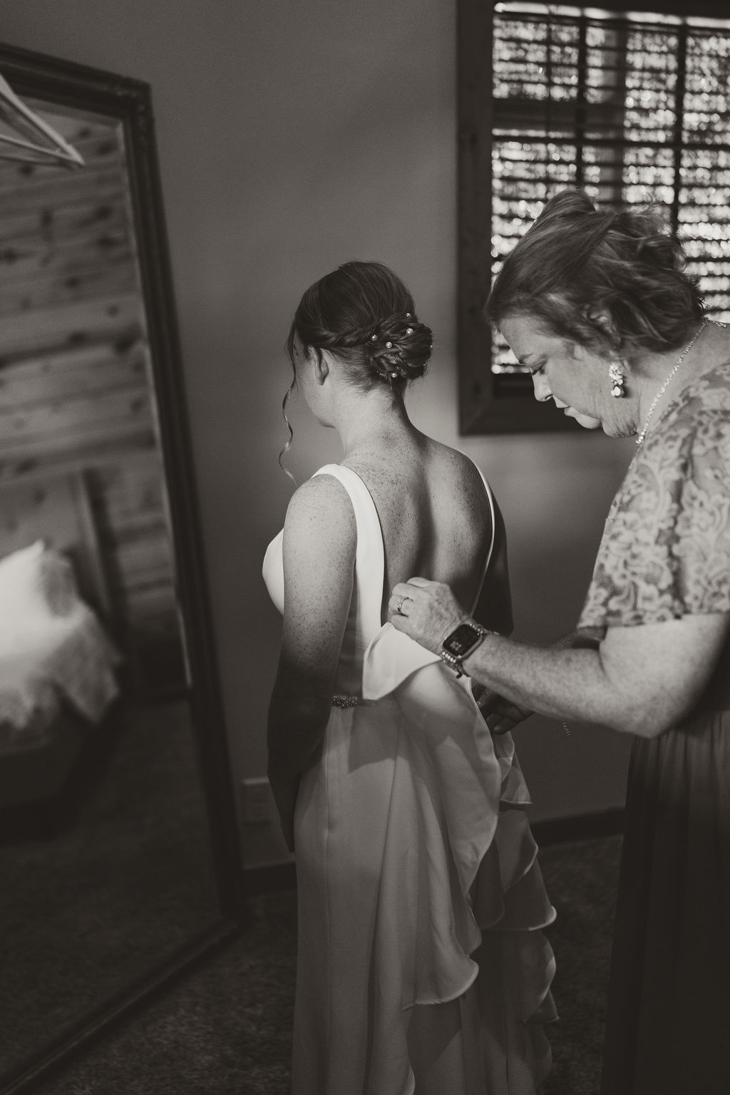 JJ & Will: black-and-white moment as someone helps JJ into her open-back gown at Covey Creek