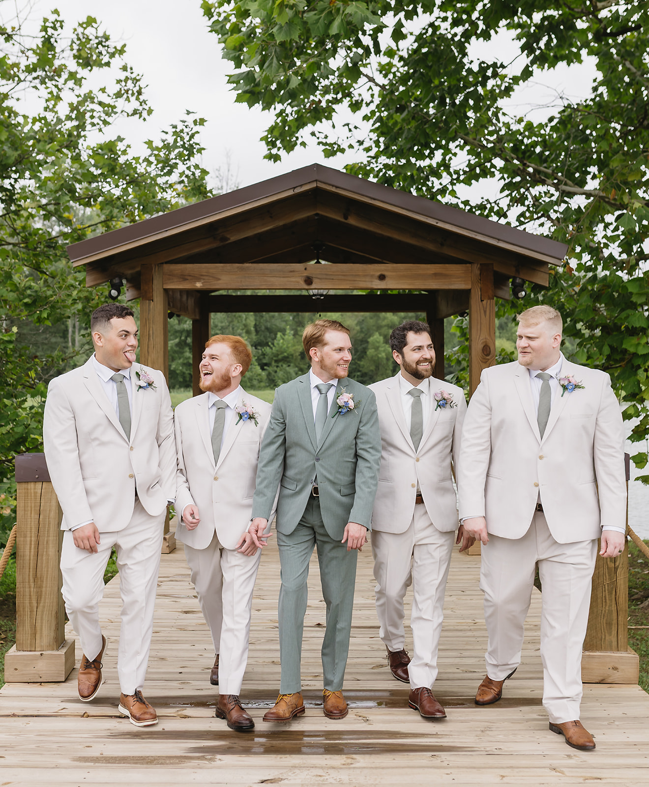 Benjamin and groomsmen laugh walking the Pond dock pavilion for Meredith & Benjamin at Covey Creek