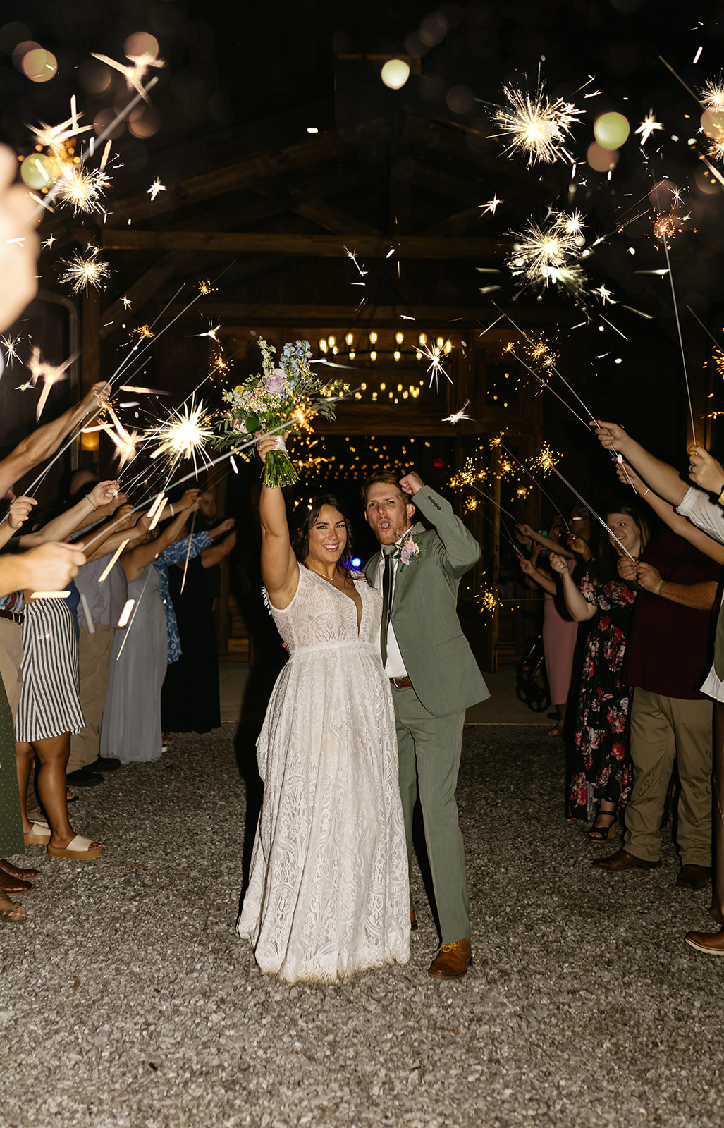 Meredith & Benjamin cheer under sparklers leaving the barn for their night exit at Covey Creek