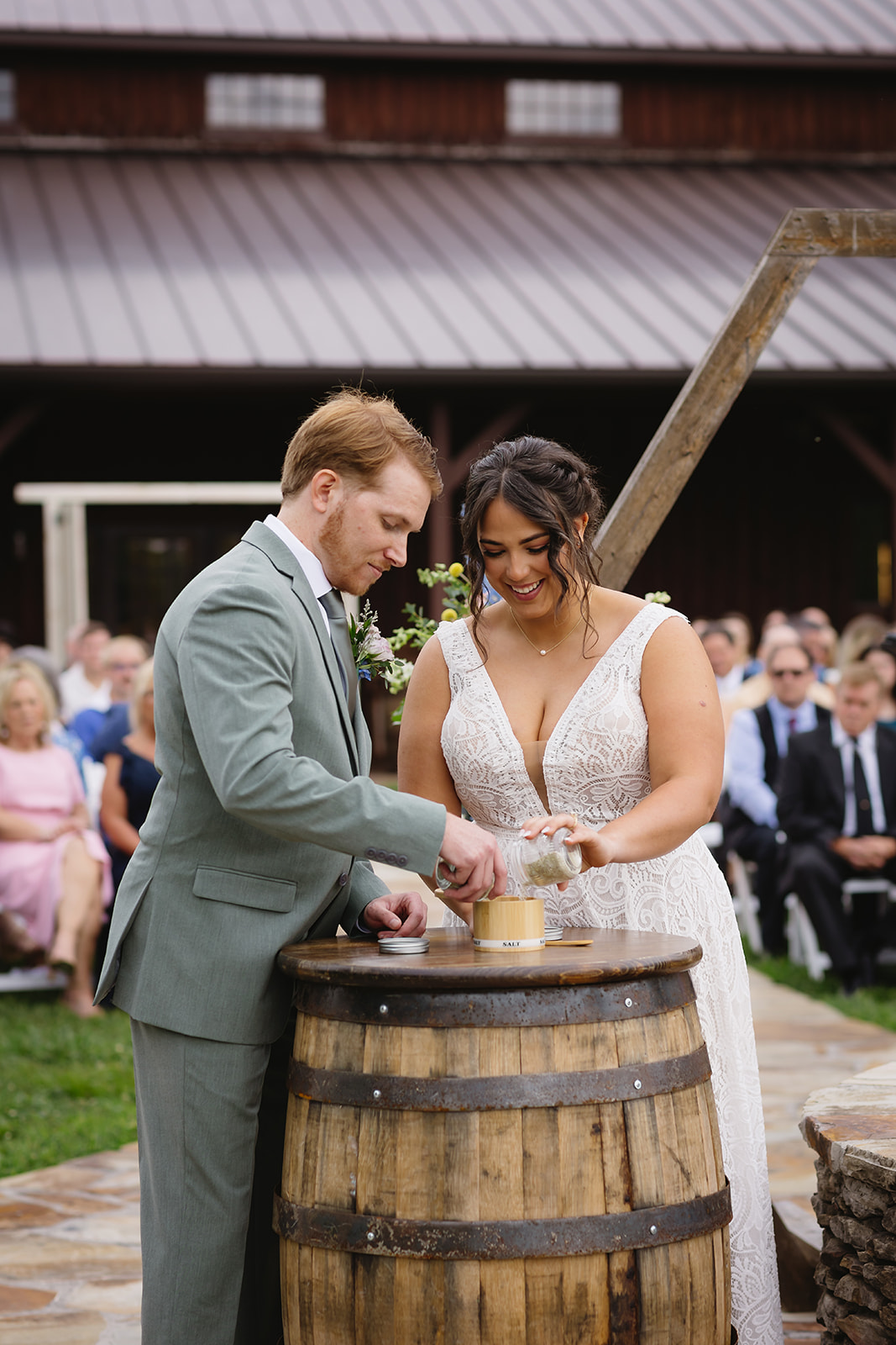 Meredith & Benjamin pour a unity salt ceremony from a wooden barrel on the Patio at Covey Creek