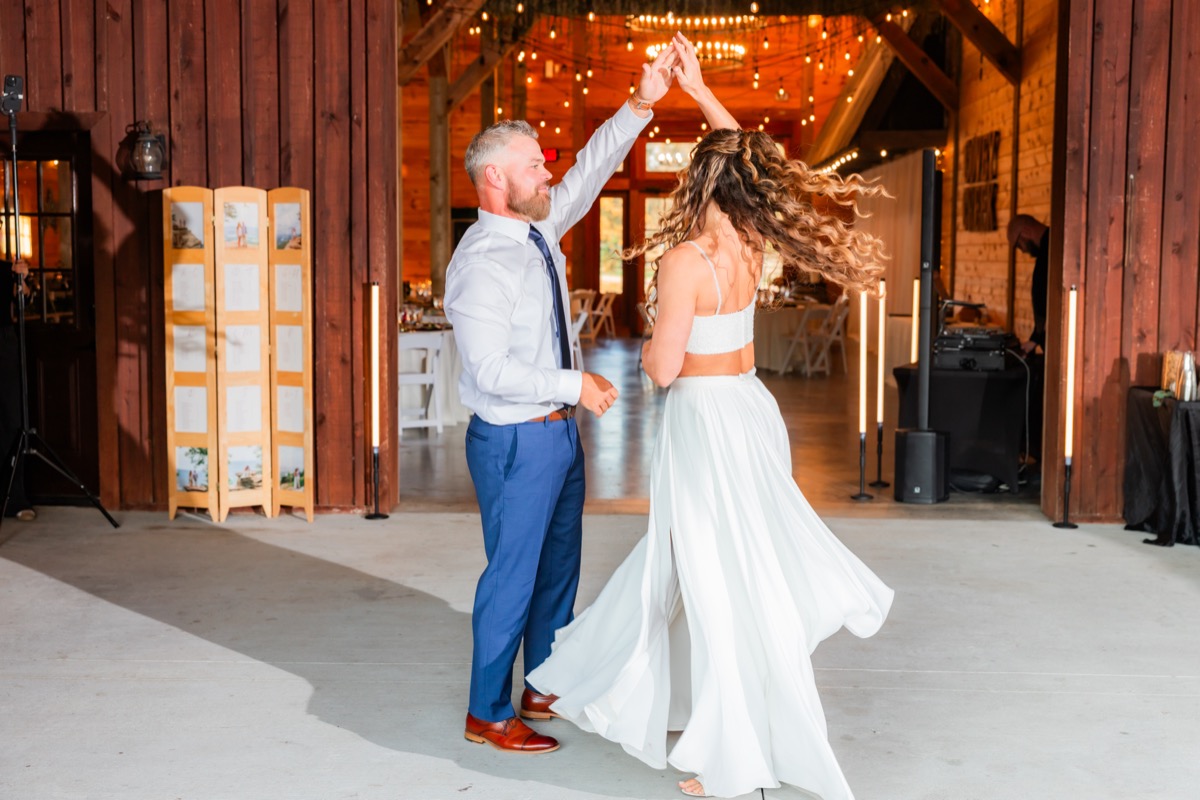Sarah & Adam spin during their first dance in the open barn doorway at their Covey Creek wedding