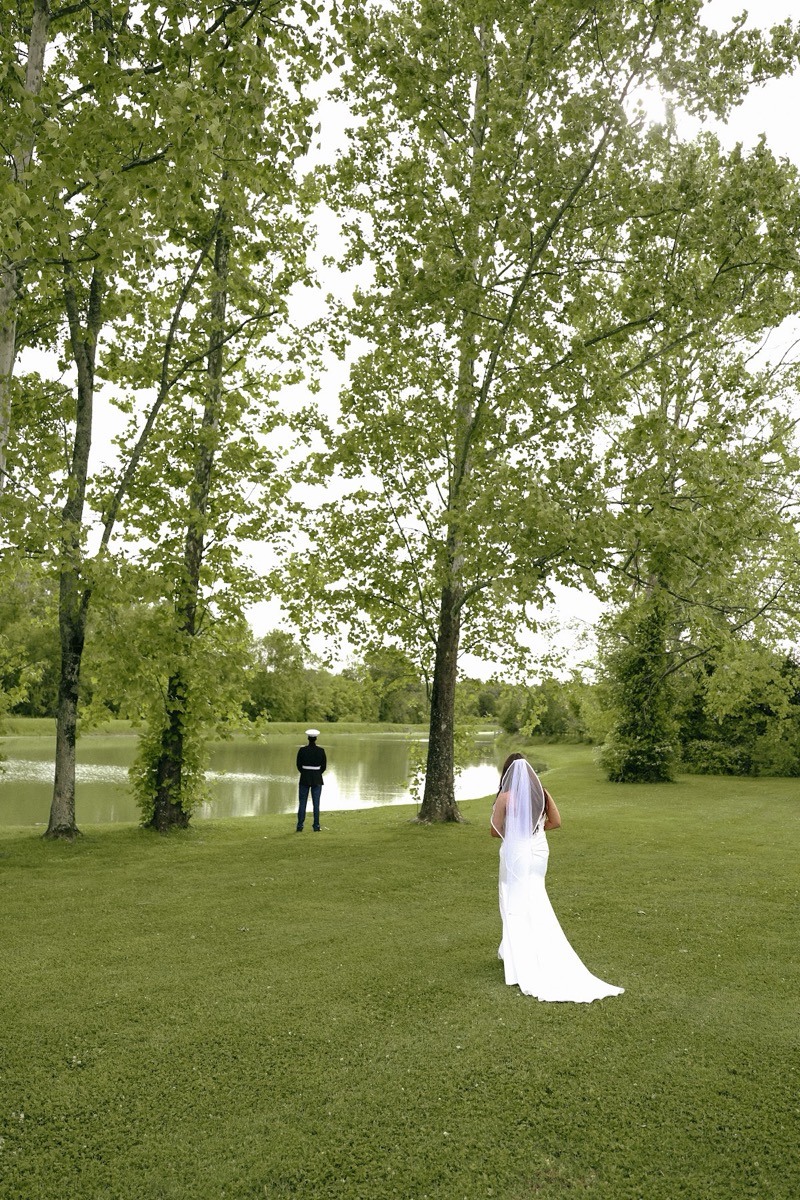 Cadence walks toward Brody in Marine blues by the Pond for Cadence & Brody's first look at Covey Creek