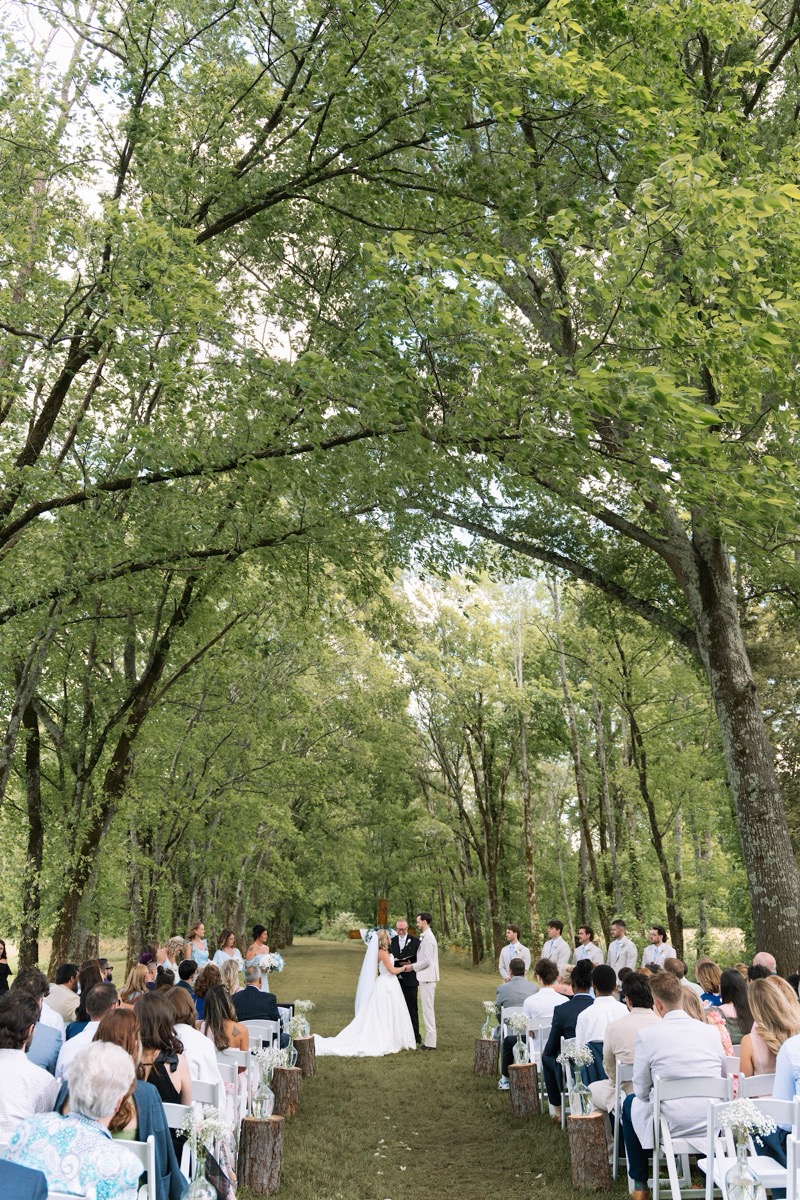 Guests face Kyley & Nick under the Tunnel of Love canopy during their outdoor ceremony at Covey Creek