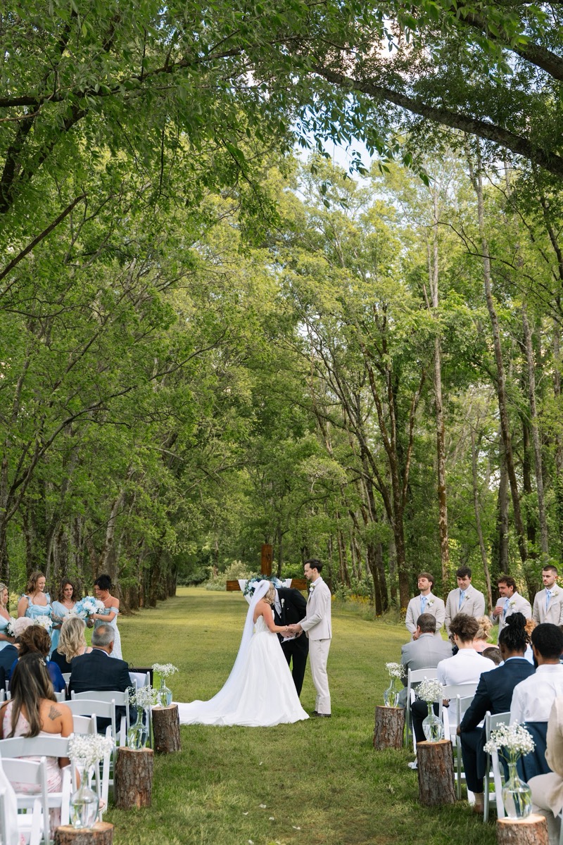 Kyley & Nick exchange vows down a tree-lined aisle at the Tunnel of Love ceremony at Covey Creek