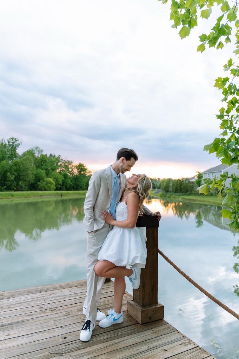 Kyley & Nick pose close on the Pond dock in sneakers under overhanging leaves at Covey Creek