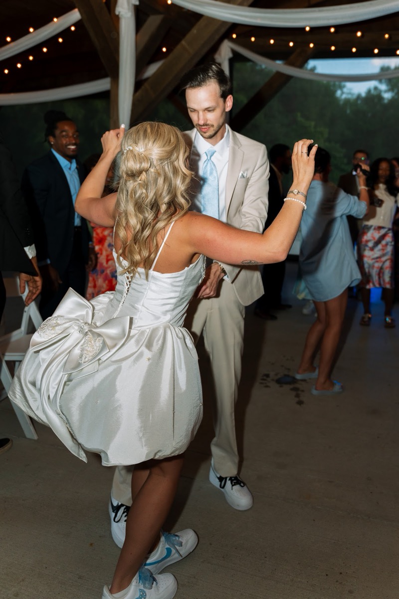 Kyley & Nick dance in sneakers under draped pavilion beams and string lights at Covey Creek
